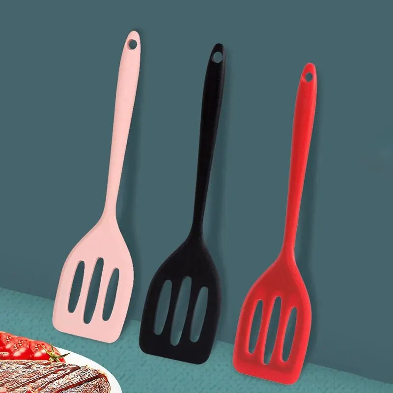 Three silicone flat bottom frying spatulas in pink, black, and red against a teal background.
