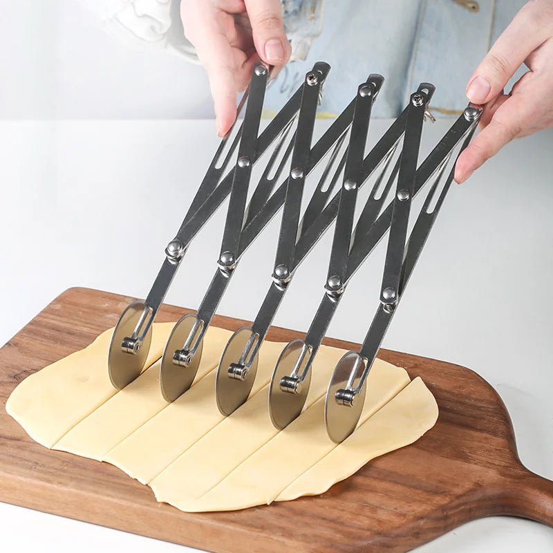 A hand is using a multi-function dough cutter set with multiple metal blades on a wooden board.
