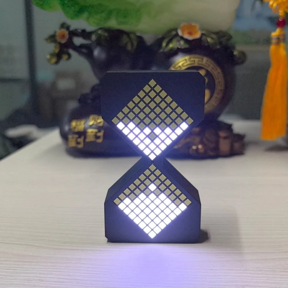 A small, dark electronic hourglass timer with a diamond pattern of bright white LEDs.