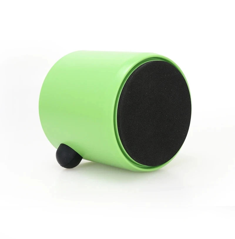 A lime green coffee knock box with a black lid and a small black rubber foot.