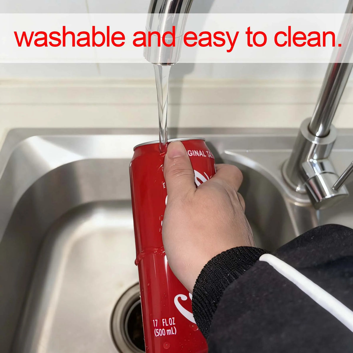 A hand is pouring liquid into a red silicone beer can sleeve in a kitchen sink.