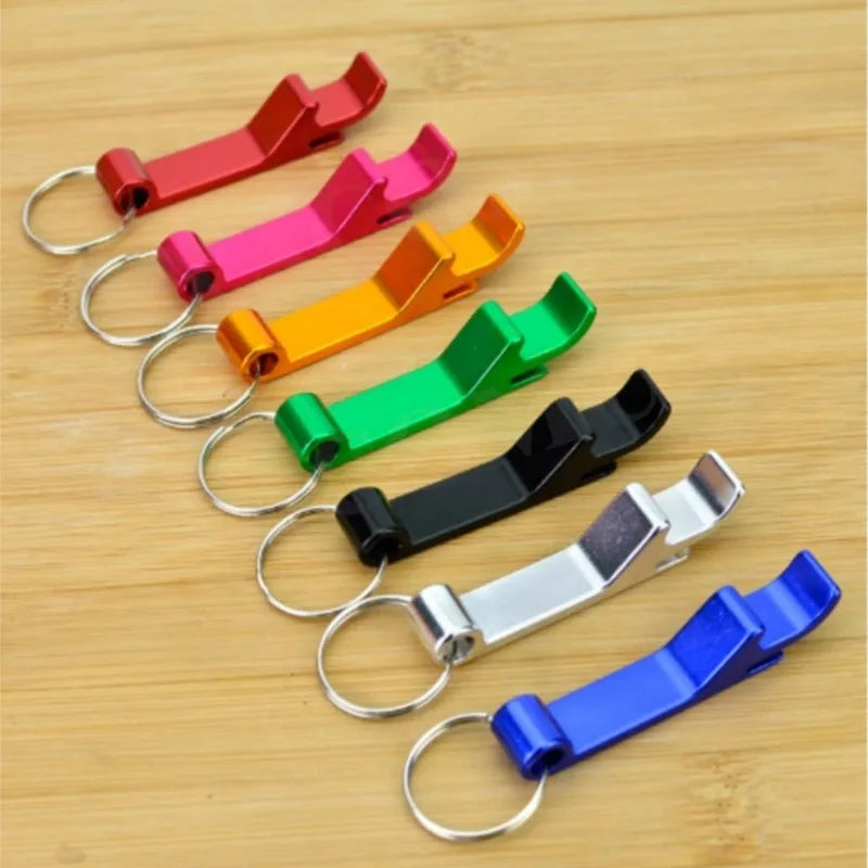 A collection of colorful portable metal bottle opener keychains arranged diagonally on a wooden surface.