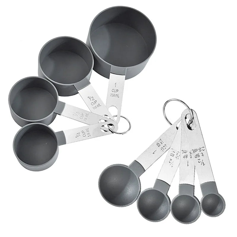 A set of precision stainless steel measuring spoons and cups in a matte gray finish.
