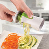 A hand is using a heavy duty vegetable spiralizer to create julienned vegetables like carrots and zucchini.