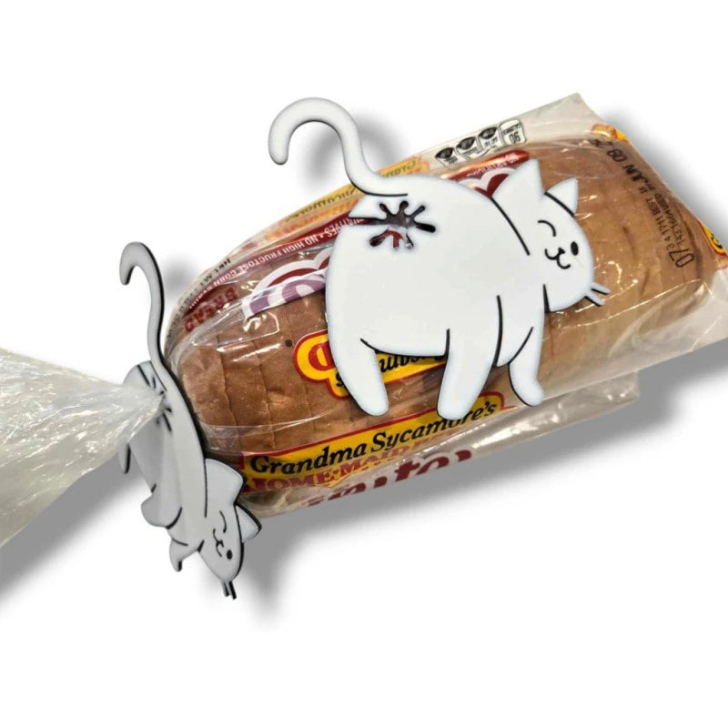 A white cat-shaped clip is shown attached to a bag of bread, used as a kitchen gadget.