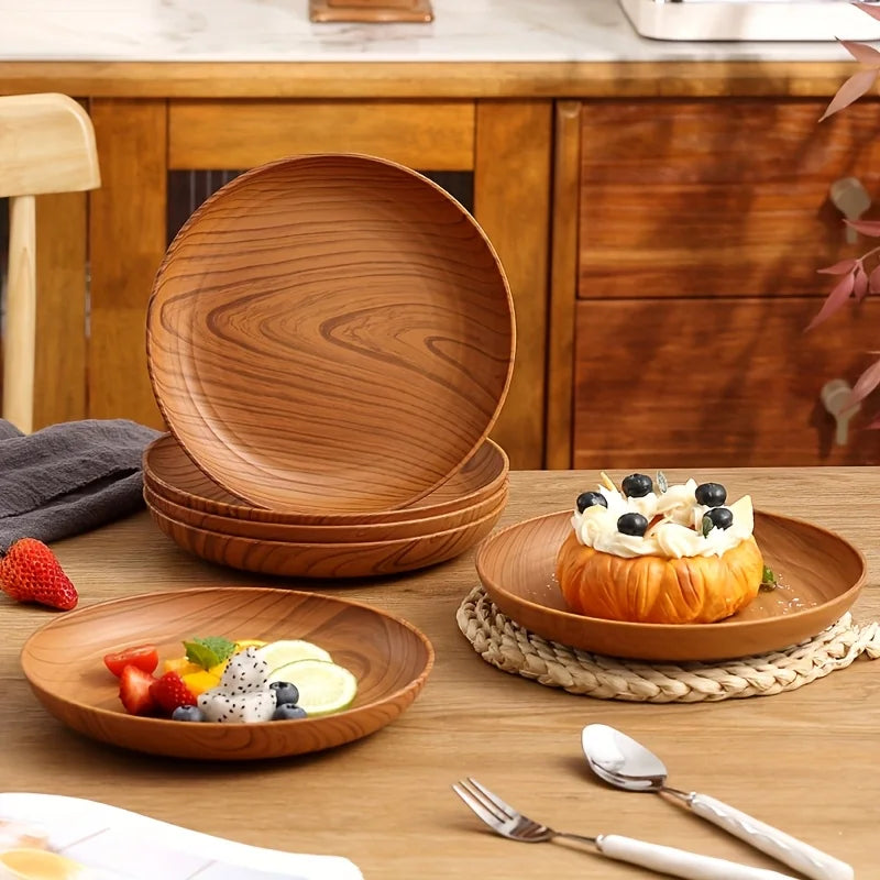 A set of wooden serving trays and a fruit arrangement on a wooden table.