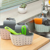A set of adjustable sink drain hanging sponge racks in gray and light green colors sitting on a wooden cutting board.