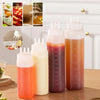 A set of multifunctional squeeze bottles in various colors, including orange, white, and pink, displayed on a wooden surface.
