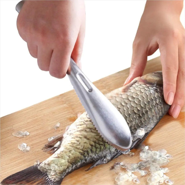 Eine Hand verwendet ein Edelstahl-Fischschaleentfernerwerkzeug, um Schuppen von einem Fisch auf einem Holzbrett zu entfernen.
