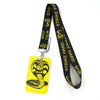 Yellow lanyard with a black snake design and a black strap featuring the words Strike Hard