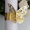 Gold laser cut butterfly napkin rings attached to a white candle.