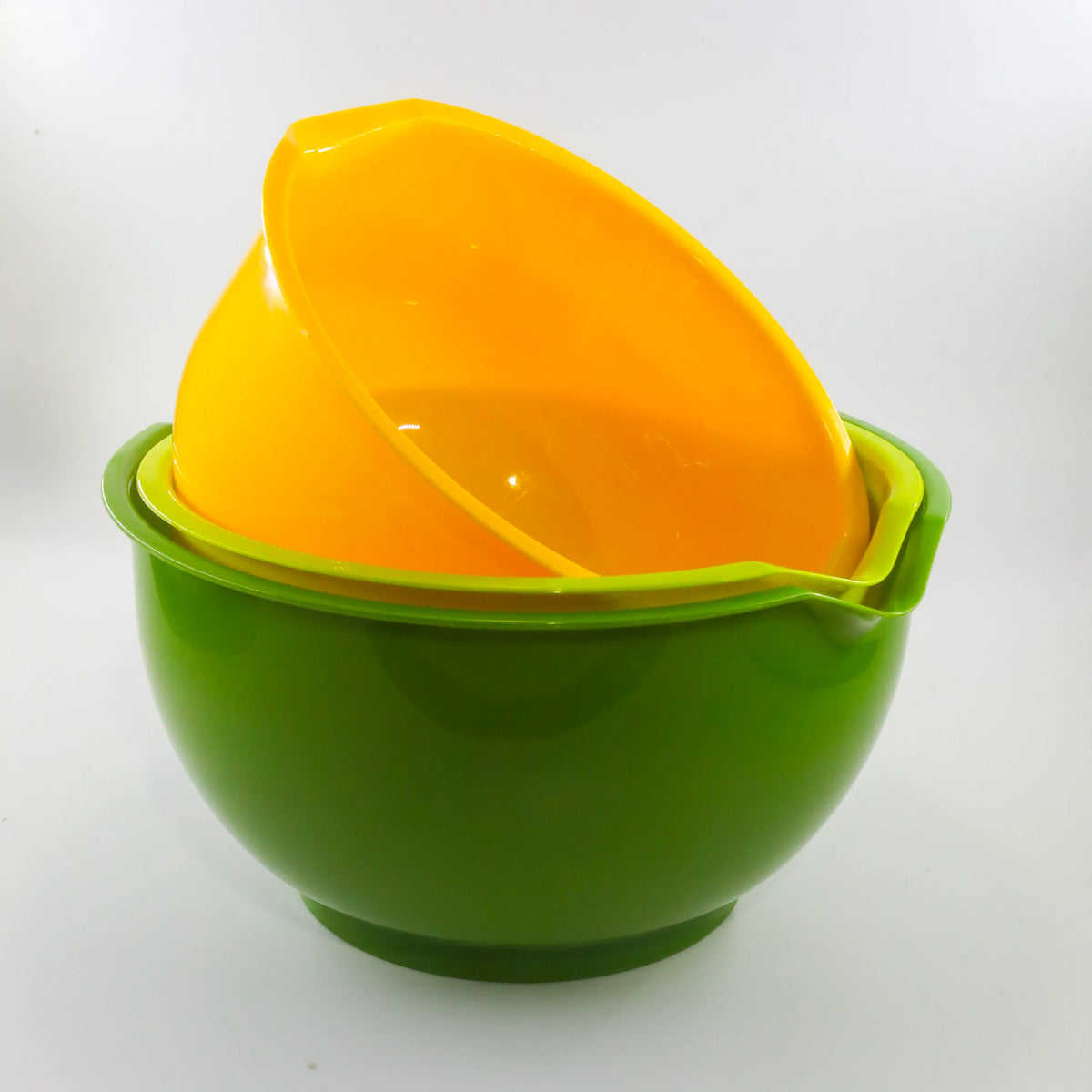 A bright orange plastic bowl is placed inside a green plastic serving dish.
