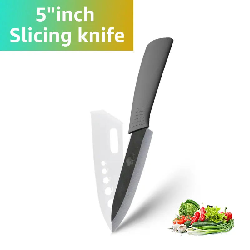 A black ceramic slicing knife is shown next to fresh vegetables like herbs and greens.