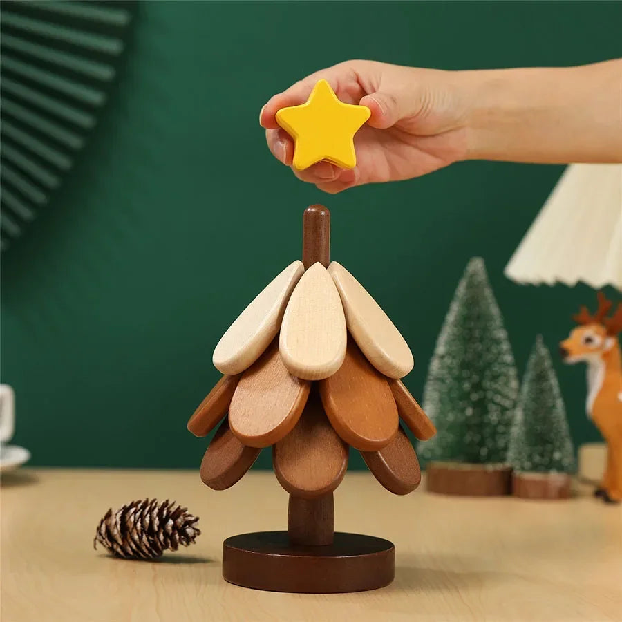 A hand holds a yellow star-shaped wooden trivet with leaves and a pinecone on a wooden base.
