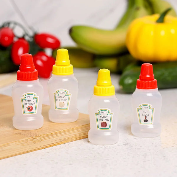 Vier Mini-Squeeze-Flaschen mit Condimenten wie Tomatenketchup, Salatdressing, Honigsenf und Sojasoße.
