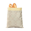 Bolsa reutilizable de cera de abeja beige llena con dos panes dorados