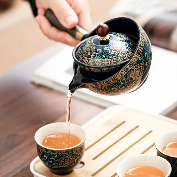 A hand pours tea from a traditional Kung Fu ceramic teapot into a small cup.