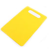 A bright yellow plastic cutting board with a white handle, shown from above.