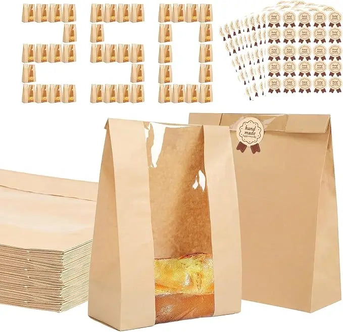 A set of kraft bakery bags with clear windows and brown seal stickers displayed next to a stack of bags.