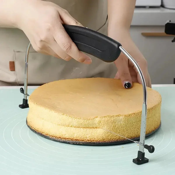 Eine Hand benutzt ein verstellbares Edelstahl-Kuchenschneider- und Messerset, um einen runden Kuchen zu schneiden.
