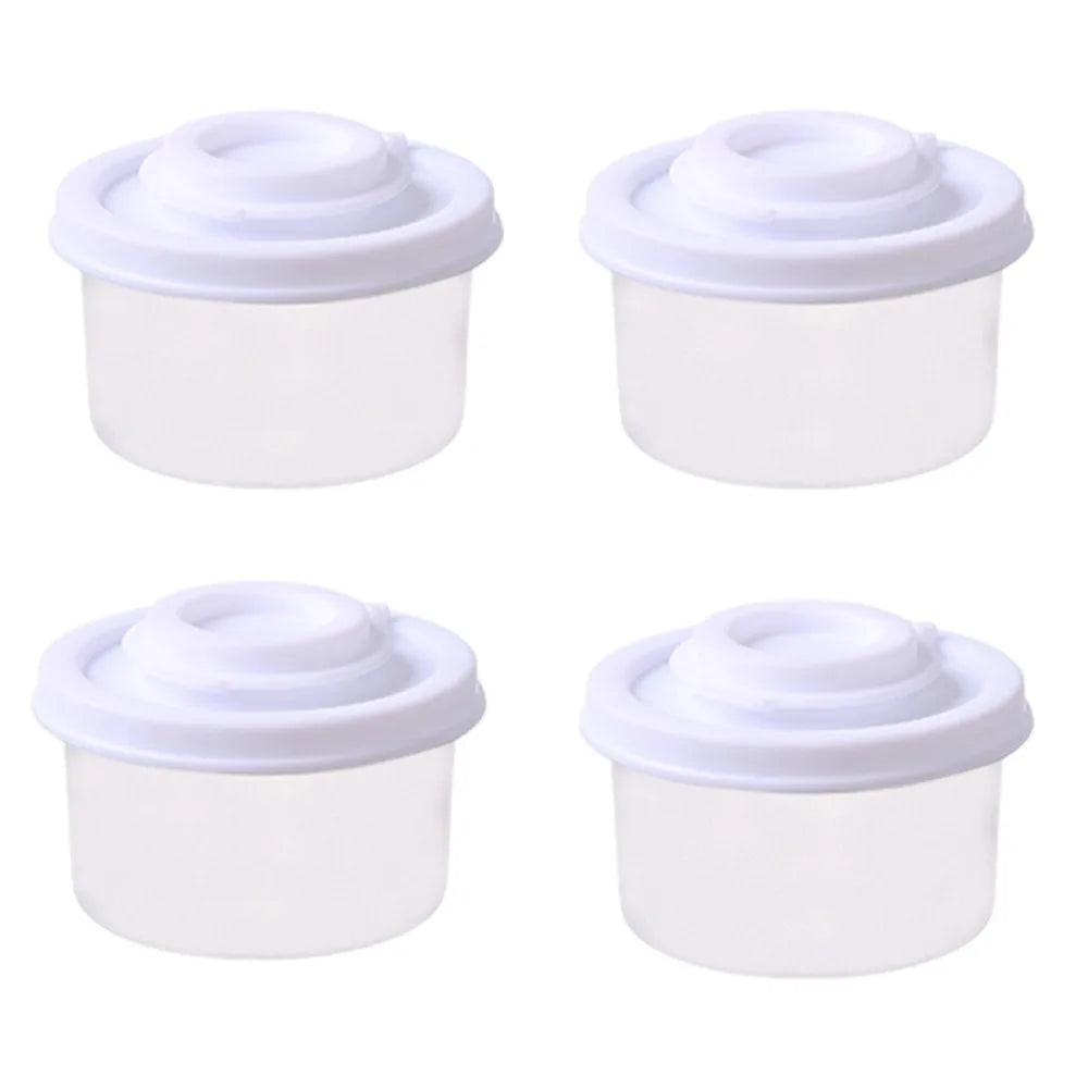Un set de quatre mini shakers d'épices blancs avec couvercles à vis pour voyager.