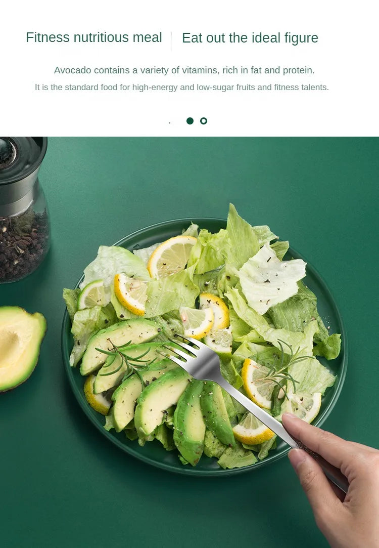 A hand cuts avocado slices and lemon wedges from a salad on a green plate.