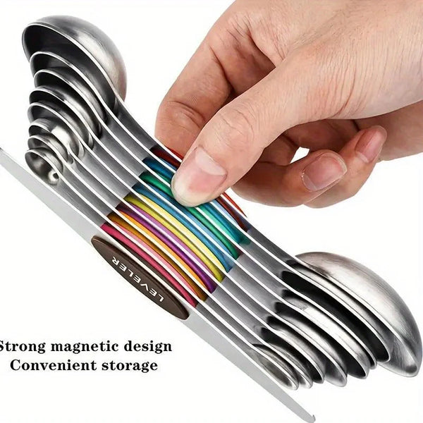 Eine Hand hält ein 9-teiliges Messlöffelset aus Edelstahl mit magnetischen Sauglöffeln und farbigen Löffeln.