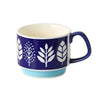Tasse à café en céramique avec motif feuille bleu et blanc sur fond violet.