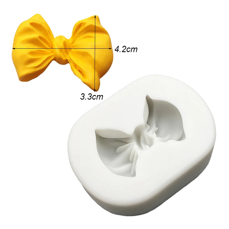 Yellow silicone baking molds shaped like bows, measuring 4.2cm by 3.3cm.