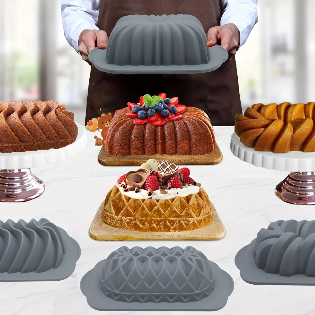 A silicone baking set featuring various cake and muffin molds, including a large bundt pan and individual tart molds.