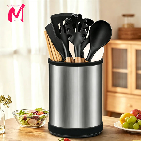 A silver utensil holder filled with black silicone and wooden kitchen tools on a wooden table.