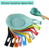 A colorful silicone spoon rest organizer rack with various colored spoons and a green spoon visible.