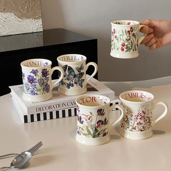 A set of four ceramic coffee mugs featuring floral patterns in shades of green, purple, and red.
