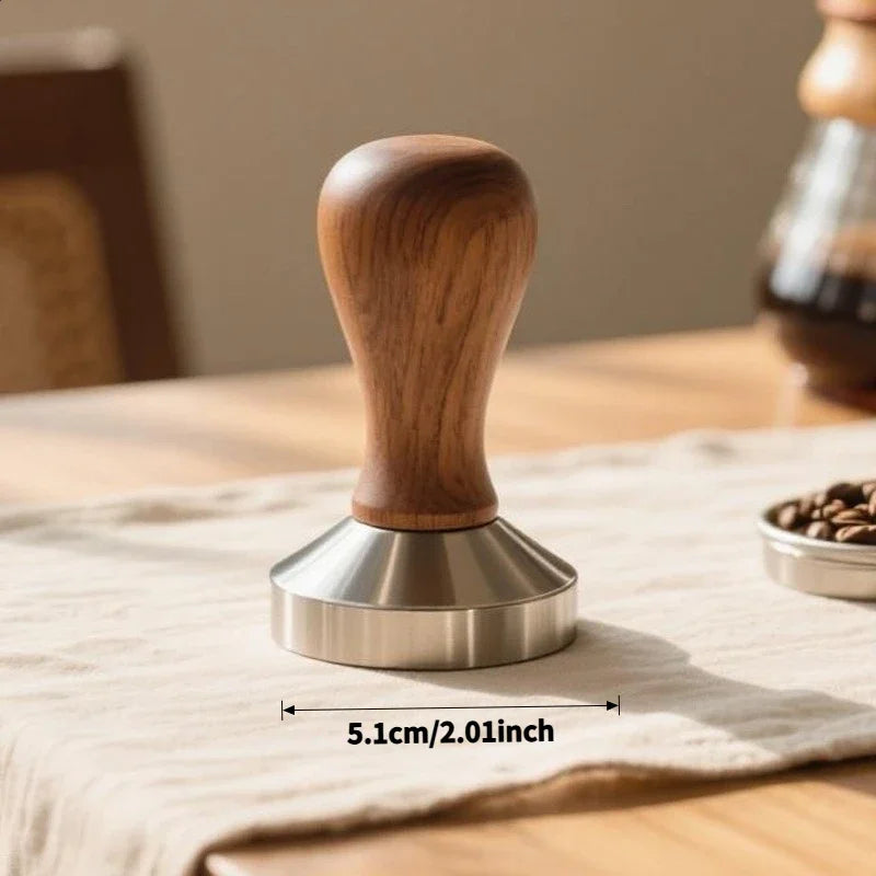 A precision espresso tamper set featuring a wooden handle and stainless steel base resting on a light linen cloth.
