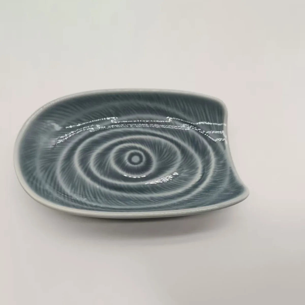 A vintage ceramic cutlery holder with a grey and white swirling pattern.