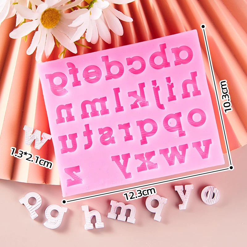 Pink silicone alphabet cake decoration molds with various letters and a floral arrangement