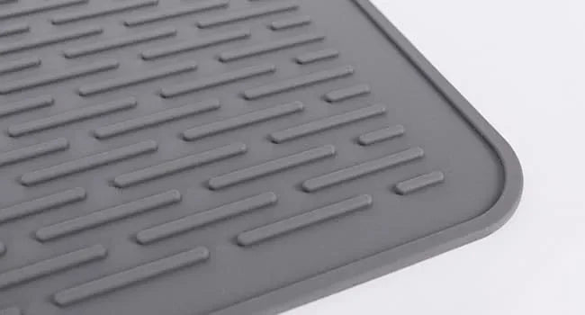 A gray silicone induction cooker protector mat with raised ridges for safety.