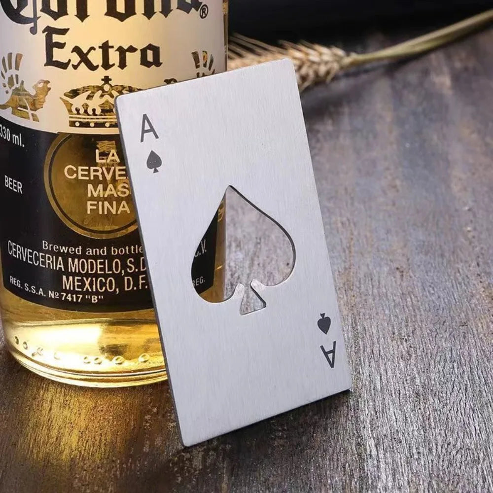 A white playing card with a shamrock cutout rests on a wooden surface next to a can of La Cervecería Modelo beer.