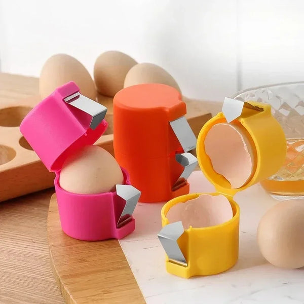 Ein Set aus drei Eierformern und -schälern in rosa, orange und gelb, neben rohen Eiern auf einer Holzoberfläche.