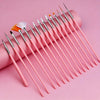 A collection of pink professional nail art brushes with various tips and a brush, arranged diagonally on a pink background.
