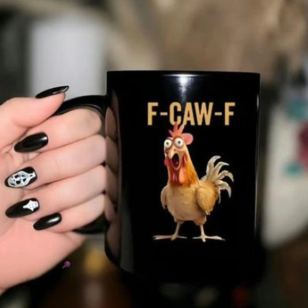 A hand holds a black mug featuring a cartoon chicken design with the text F-CAW-F.