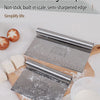 Stainless steel dough scraper and cutter with a measuring scale resting on a wooden board.