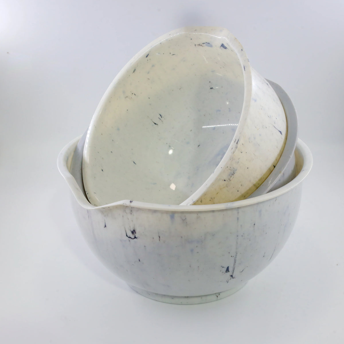 A stack of multi-sized, translucent white plastic salad bowls for fruits and snacks.