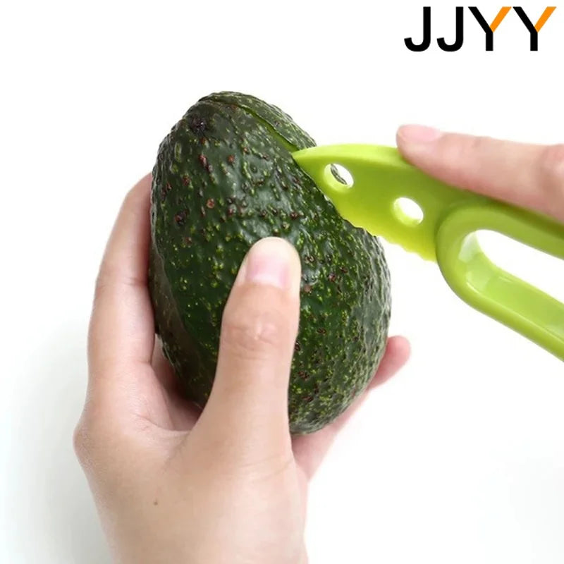 A hand holds a green avocado being sliced by a bright lime green fruit slicer and corer tool.