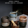 A set of dark ceramic matcha whisks and bowls displayed on a wooden surface.