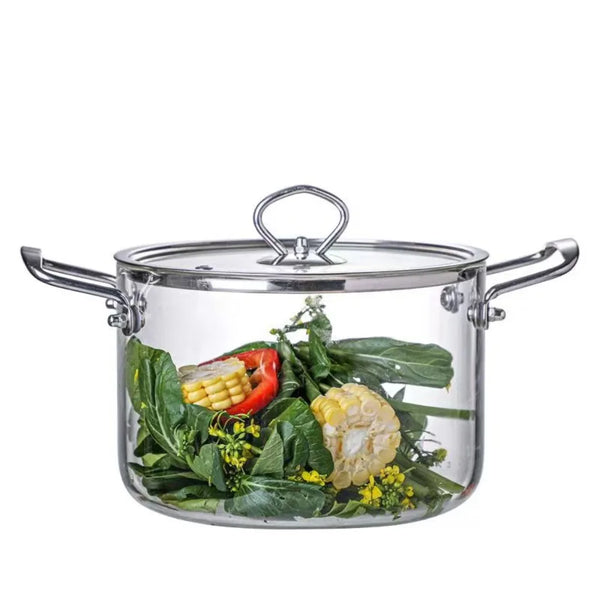 A clear glass cookware pot with a lid and double handles filled with fresh green herbs and yellow corn.
