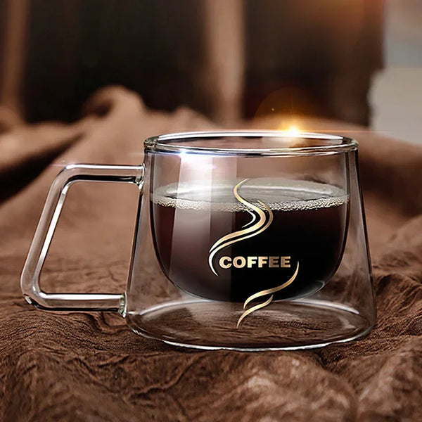 Klare doppelwandige Glas-Espresso-Tasse mit dunkem Kaffee, auf braunem Stoff.