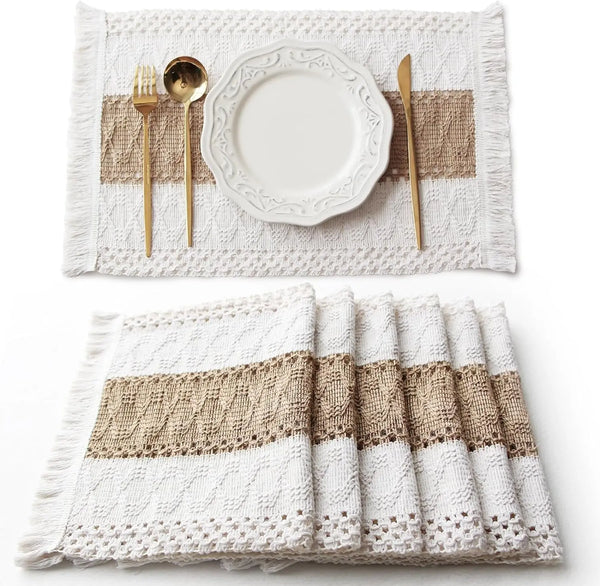 Ein Set aus Naturbaumwoll-Platzsets mit beige Streifen und weißen Fransen, auf denen Besteck liegt.