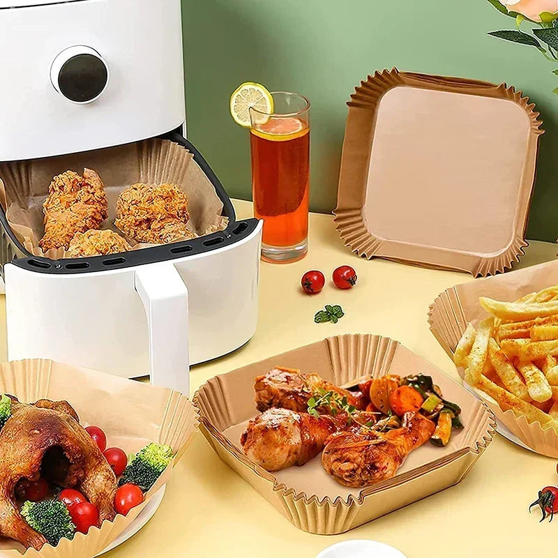 A set of reusable silicone baking liners and food items displayed next to an air fryer component.