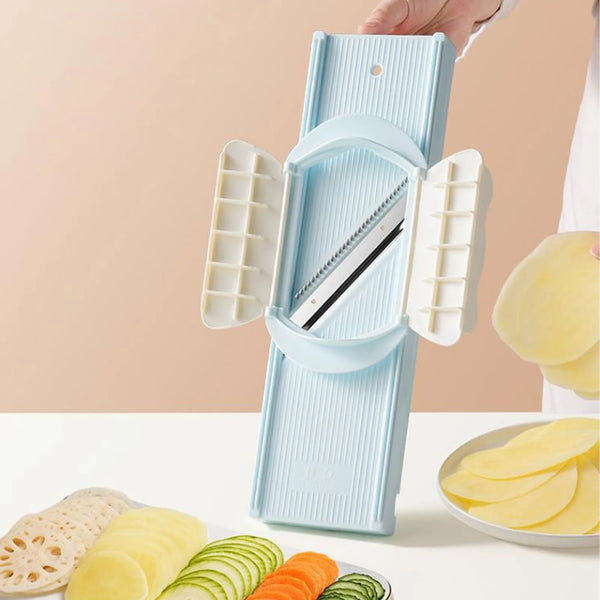 Eine Hand hält ein hellblaues multifunktionales Gemüse-Slicer- und Reibe-Set mit mehreren Schneidscheiben.
